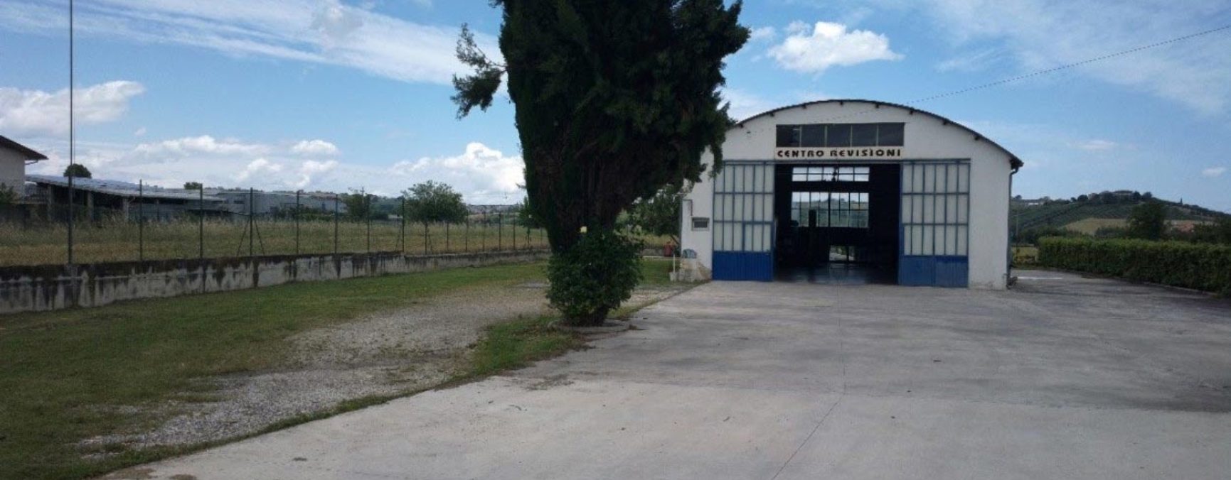 Ingresso del centro revisioni Tulini, capannone bianco con portone blu
